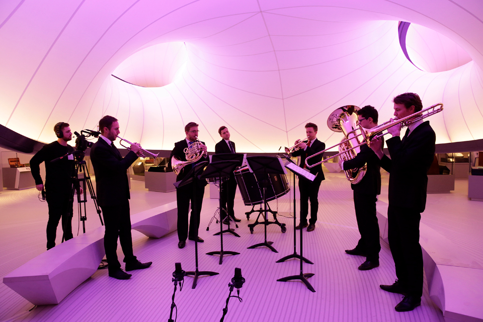 A group of male brass players, performing in a sixtet, in an event at the Science Museum's Maths gallery.